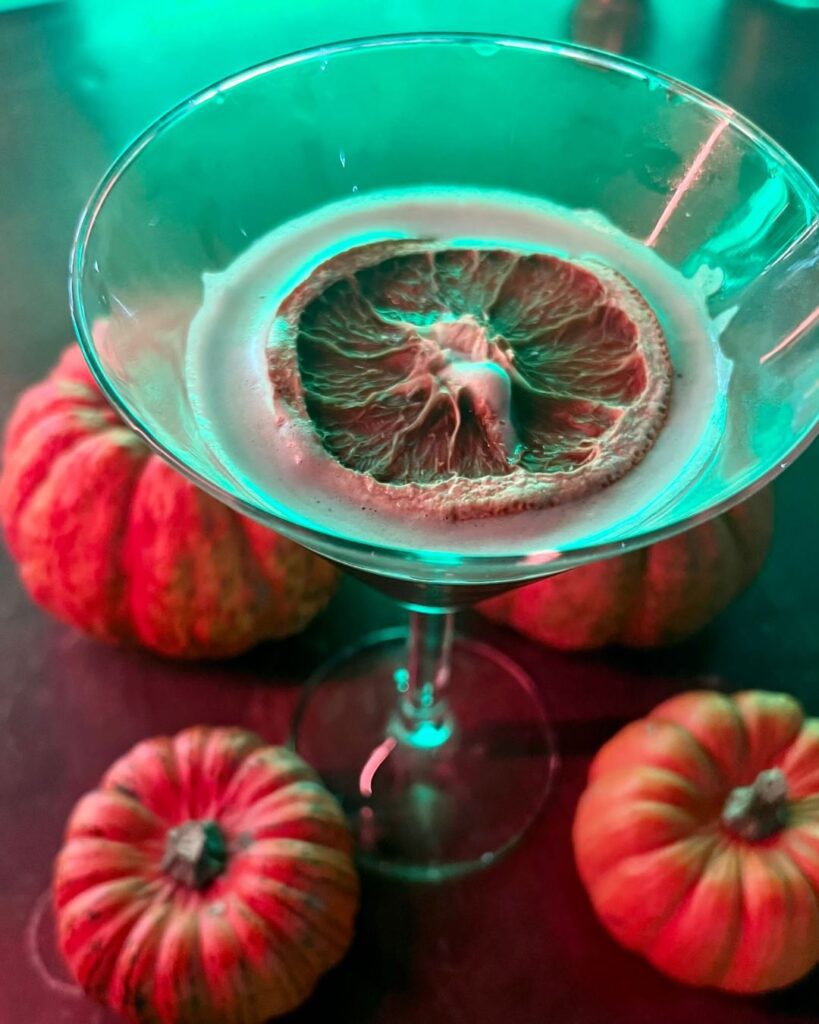 themed halloween cocktail with decoration pumpkins in a martini glass